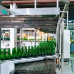 Jalur produksi massal di pabrik dengan mesin otomatis dan botol kaca